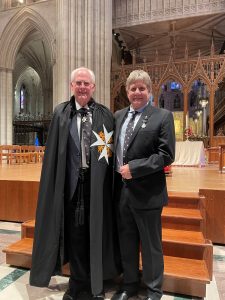 Two gentlemen stand side by side inside the Washington Cathedral.